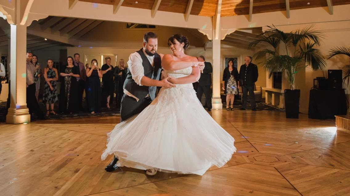 A couple twirling together on the dance floor at their wedding